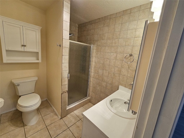 bathroom with tile patterned flooring, vanity, toilet, a textured ceiling, and a shower stall