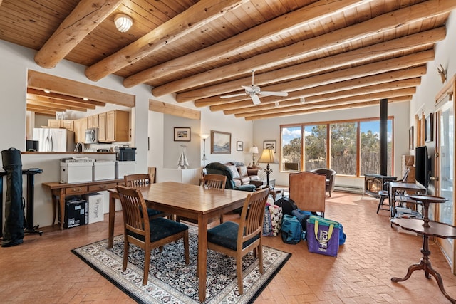 dining space with ceiling fan, a wood stove, brick floor, wooden ceiling, and beamed ceiling