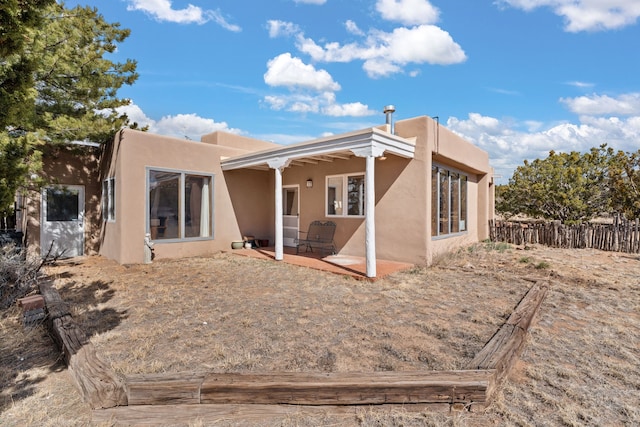 back of property with fence, a patio, and stucco siding