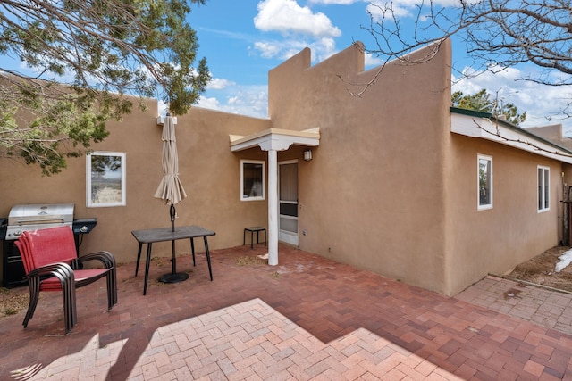 back of property with a patio area and stucco siding