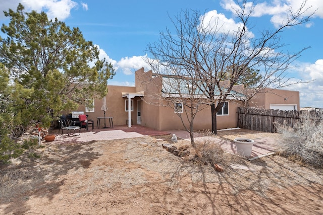 back of house with a patio, fence, and stucco siding