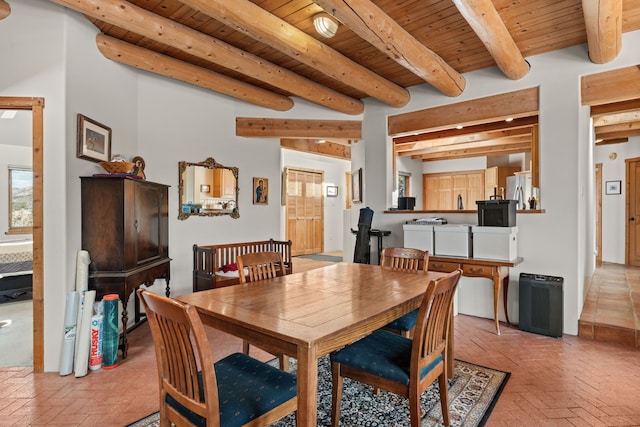 dining space with brick floor, beam ceiling, and wooden ceiling