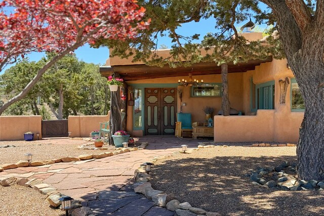 rear view of house with a gate, stucco siding, and covered porch