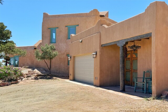 view of side of home with an attached garage and stucco siding