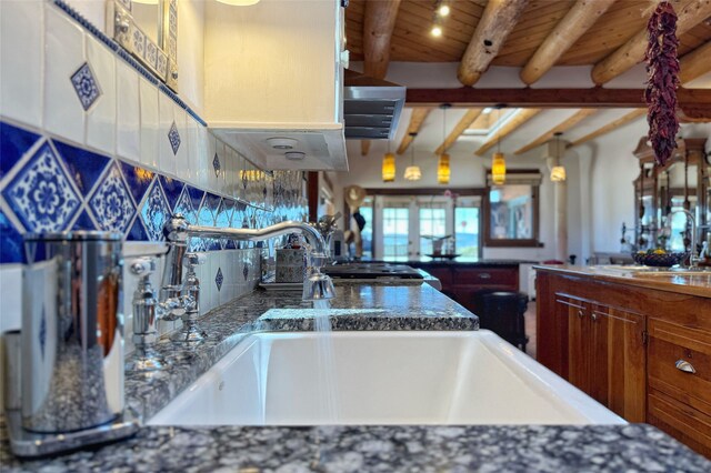 kitchen with french doors, beamed ceiling, wooden ceiling, and a sink