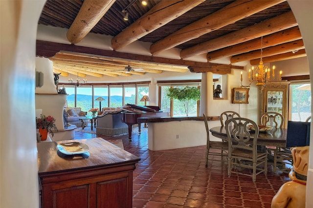 dining room with ceiling fan with notable chandelier, beam ceiling, and a healthy amount of sunlight
