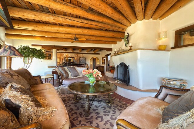 living room featuring wooden ceiling, a ceiling fan, and beam ceiling