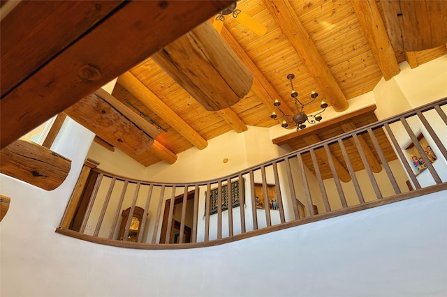 staircase featuring lofted ceiling with beams and wood ceiling