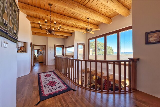 hall featuring wood ceiling, a chandelier, wood finished floors, beamed ceiling, and an upstairs landing