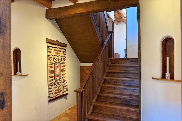 stairs with tile patterned flooring and vaulted ceiling with beams