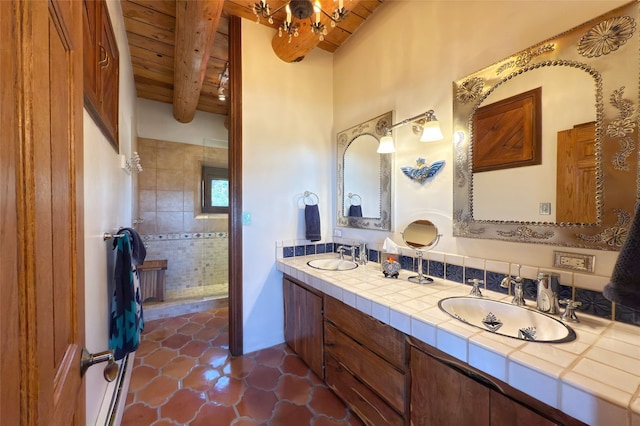 bathroom with beamed ceiling, tiled shower, wood ceiling, tile patterned floors, and a sink