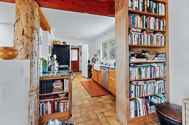 kitchen with fridge, a sink, brick floor, freestanding refrigerator, and stainless steel dishwasher