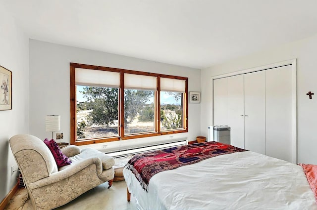bedroom with a closet and a baseboard heating unit