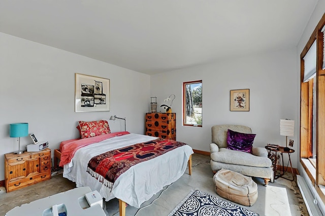 bedroom featuring concrete flooring and baseboards