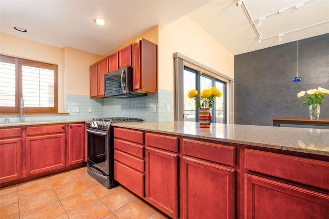 kitchen featuring stainless steel appliances, light stone counters, a sink, and dark brown cabinets