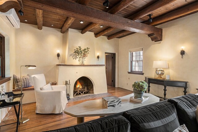 living room featuring wood ceiling, a fireplace, beam ceiling, a wall mounted air conditioner, and wood finished floors