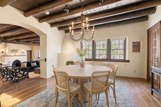 dining area featuring wooden ceiling, a notable chandelier, beam ceiling, and wood finished floors
