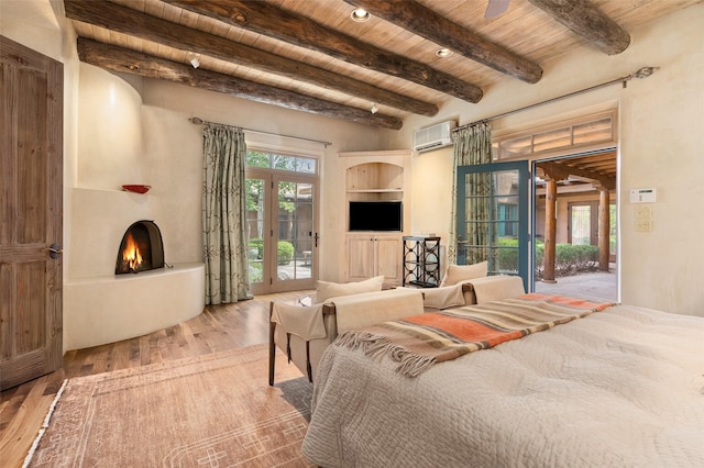bedroom featuring access to exterior, a large fireplace, a wall mounted AC, wood finished floors, and wooden ceiling