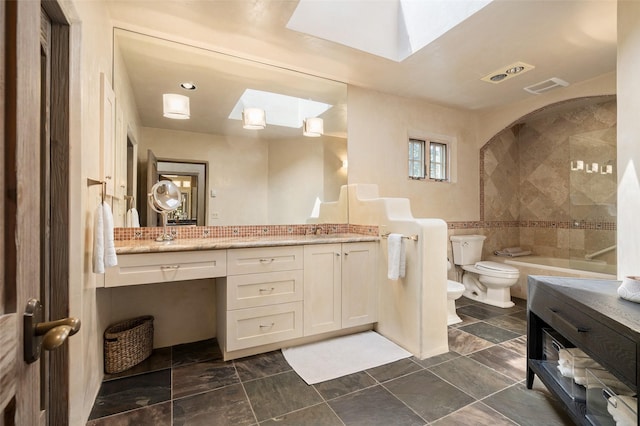 bathroom featuring vanity, visible vents, toilet, a bidet, and a skylight