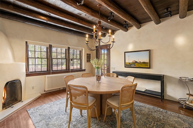 dining room with radiator, wood ceiling, beam ceiling, and a chandelier