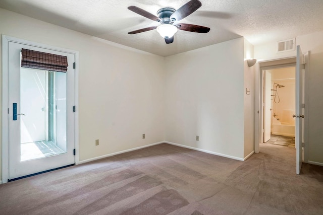 unfurnished room featuring carpet floors, a textured ceiling, a ceiling fan, baseboards, and visible vents