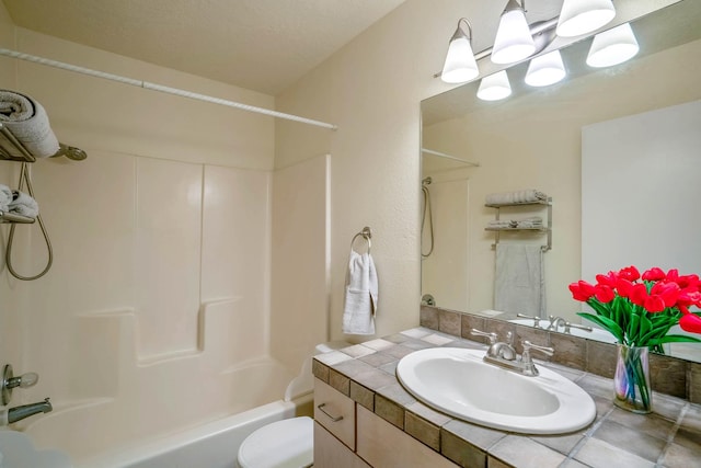 bathroom with toilet, shower / tub combination, and vanity