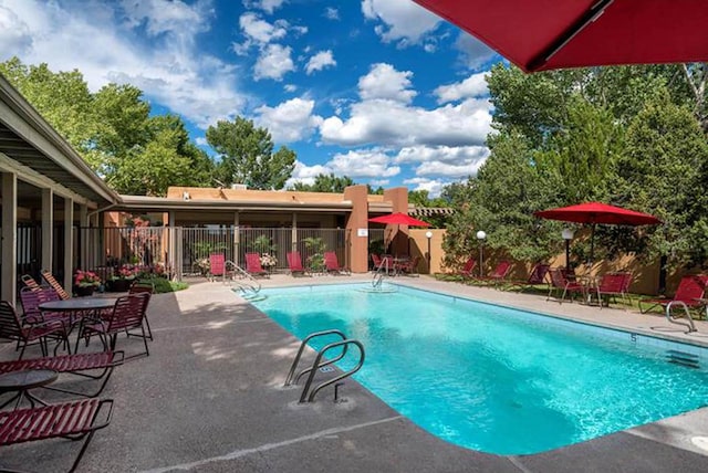 community pool featuring fence and a patio