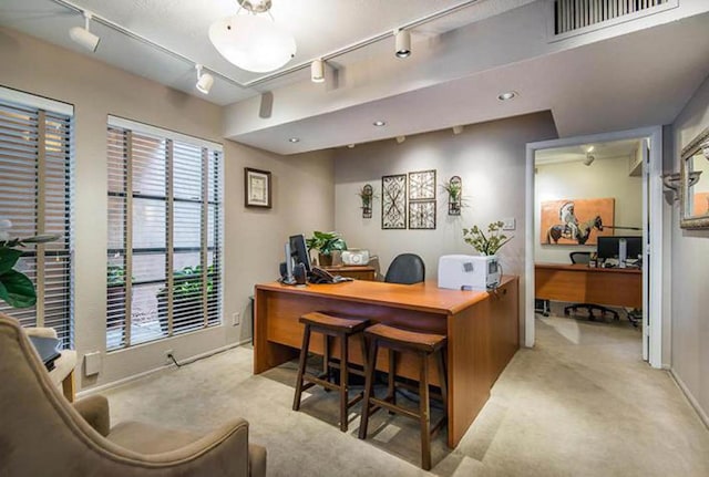 office with carpet flooring, rail lighting, visible vents, and a healthy amount of sunlight