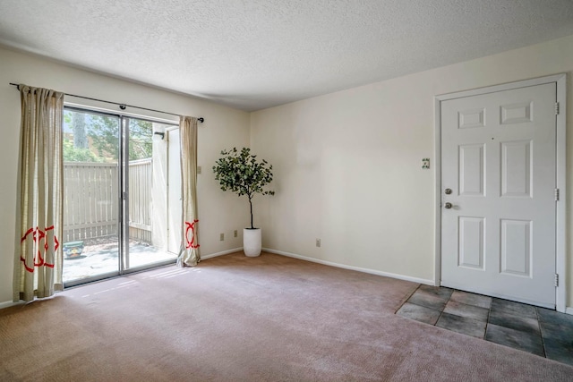carpeted empty room featuring baseboards and a textured ceiling