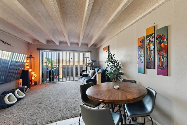 dining space featuring carpet floors, a textured ceiling, tile patterned floors, and beam ceiling