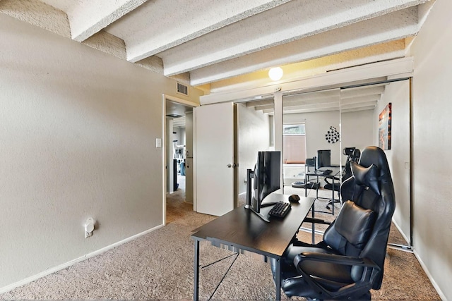 home office featuring carpet flooring, baseboards, visible vents, and beam ceiling