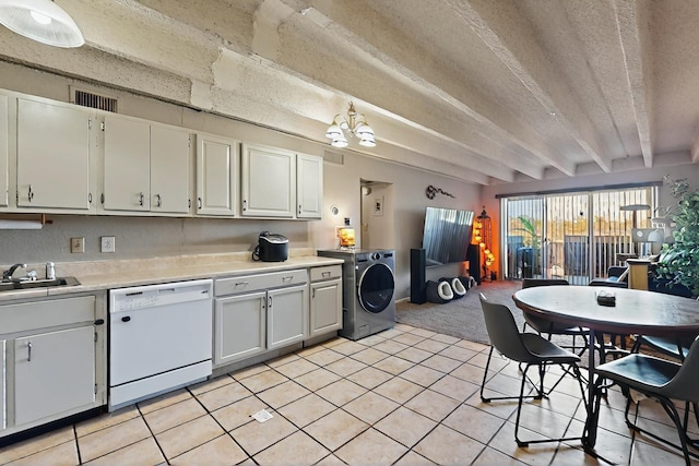 kitchen with a sink, dishwasher, light countertops, washer / clothes dryer, and light tile patterned floors
