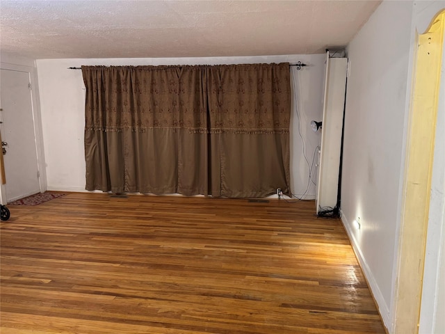 unfurnished room featuring baseboards and wood finished floors