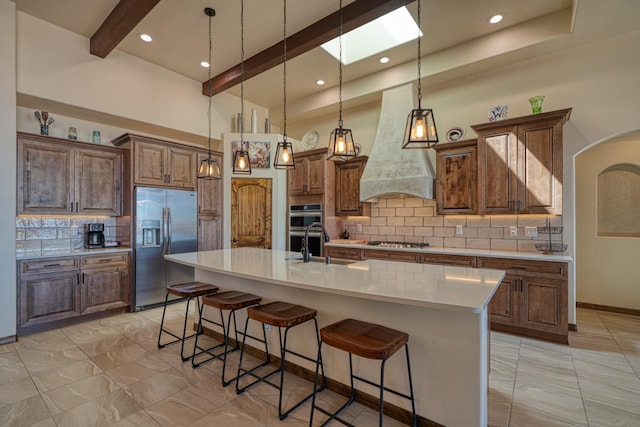 3415 Ramadan Ct NE, Rio Rancho, NM 87144 - kitchen with decorative backsplash, light countertops, custom range hood, appliances with stainless steel finishes, and a skylight