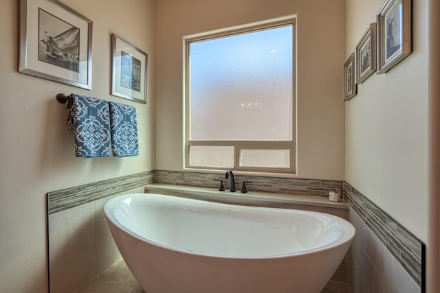 3415 Ramadan Ct NE, Rio Rancho, NM 87144 - bathroom with tile patterned floors, tile walls, wainscoting, and a freestanding bath