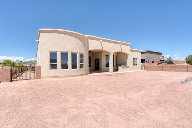 3415 Ramadan Ct NE, Rio Rancho, NM 87144 - rear view of house featuring a gate, ceiling fan, stucco siding, and fence