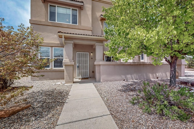 4359 San Benito St Unit B, Santa Fe, NM 87507 - doorway to property featuring stucco siding, a tile roof, and fence