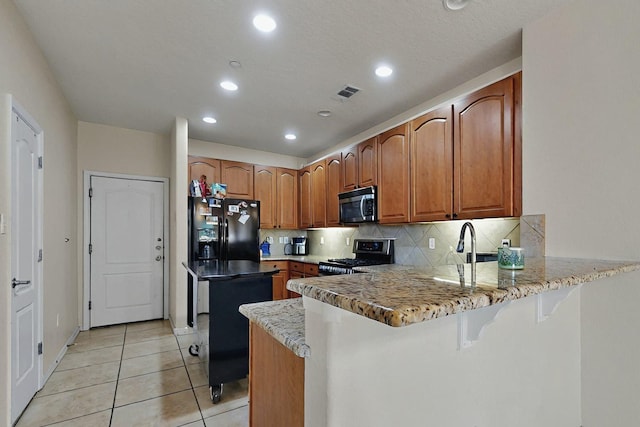 4359 San Benito St Unit B, Santa Fe, NM 87507 - kitchen with a peninsula, light tile patterned floors, stainless steel appliances, visible vents, and recessed lighting