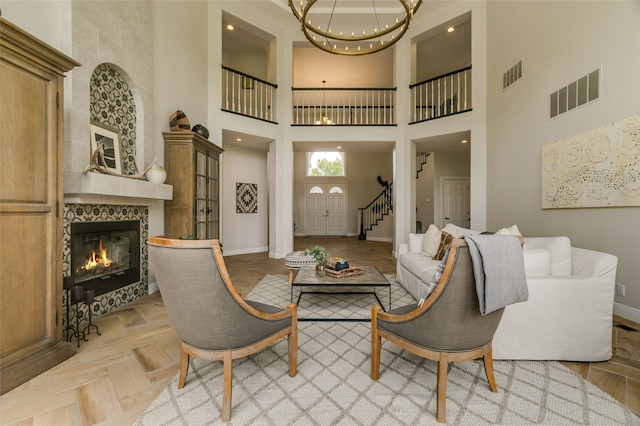 living room with a chandelier, visible vents, and baseboards