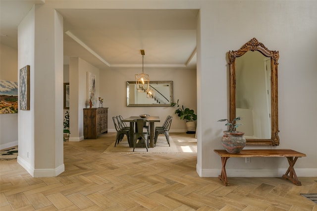 dining area featuring a tray ceiling and baseboards