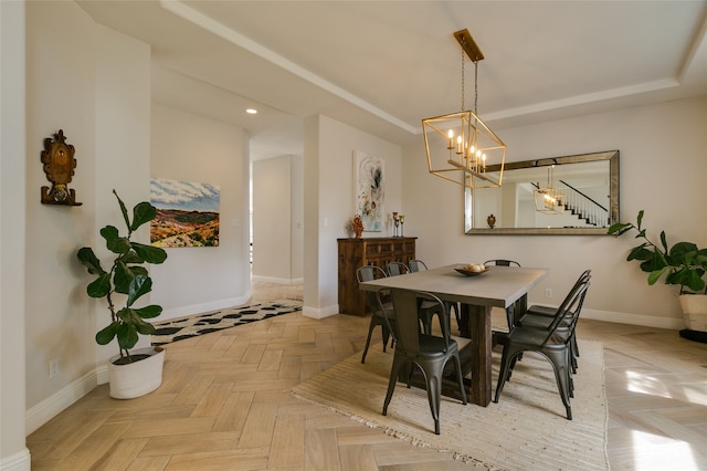 dining area featuring a chandelier, baseboards, a raised ceiling, and recessed lighting