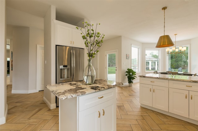 kitchen featuring stainless steel fridge with ice dispenser, white cabinets, baseboards, and light stone countertops