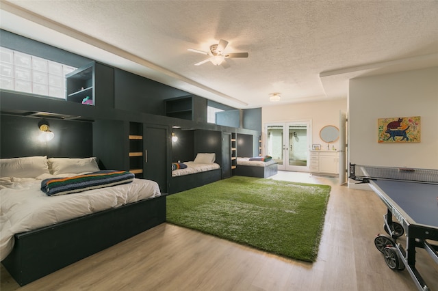 bedroom featuring a textured ceiling, french doors, and wood finished floors