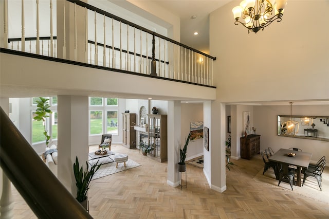 stairs featuring an inviting chandelier, baseboards, a high ceiling, and recessed lighting