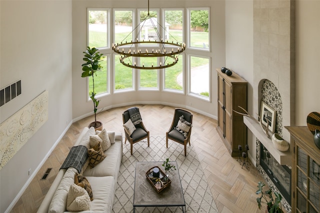 living room featuring a chandelier, baseboards, and visible vents