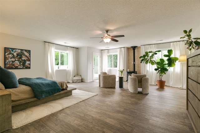 bedroom with ceiling fan, a textured ceiling, access to exterior, and wood finished floors