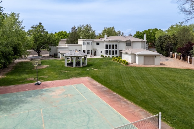 back of property with a yard, a gazebo, stucco siding, and fence