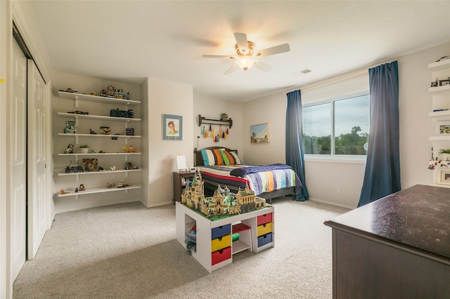 carpeted bedroom with a closet, visible vents, baseboards, and a ceiling fan