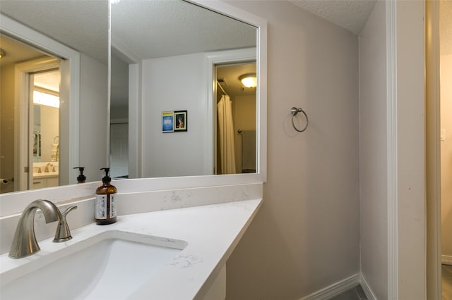 bathroom featuring a textured ceiling and vanity