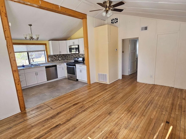3546 Questa Dr, Los Alamos, NM 87544 - kitchen with ceiling fan with notable chandelier, white cabinets, visible vents, appliances with stainless steel finishes, and lofted ceiling